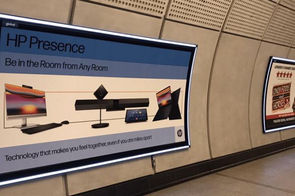An advertisement in a subway station corridor promotes HPPresence with the tagline "Best in Room from Any Room." The ad features HP devices like monitors, a webcam, a keyboard, and laptops. Enhanced by modern design and LED lighting for cross rail, the curved walls create an engaging visual experience.